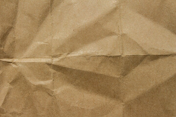 Brown crumpled kraft paper texture with deep folds and creases