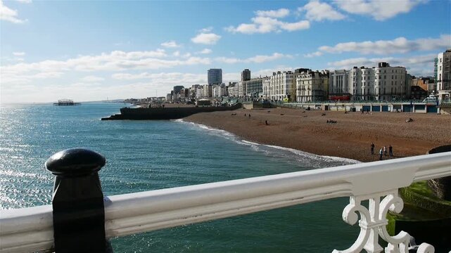Brighton and Hove, East Sussex, England. A view of the popular English seaside resort looking west from Brighton Pier with the iconic remains of the West Pier visible in the distance.