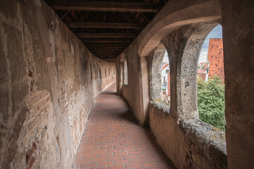 Obraz premium Backofenturm Innenseite mit Ziegelboden und Rundbogenarkaden an der umlaufenden Stadtmauer mit überdachtem Wehrgang Löpsinger Mauer in Nördlingen mit Ausblick auf historische Altstadt. 