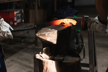 Blacksmith manually forging the molten metal