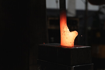 Blacksmith working with a piece of red hot metal.