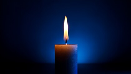 Fototapeta premium burning candle in the dark on a dark blue background