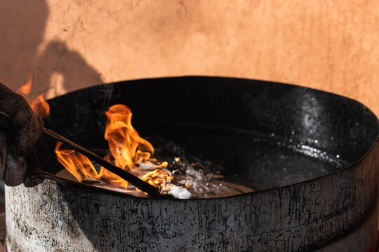 Blacksmith forges and tempering metal horseshoe in jar with water at forge