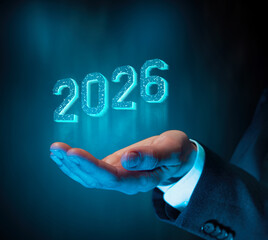 Glowing futuristic 2026 numbers hover above the hand of a businessman hand, representing technology, innovation, progress, and upcoming opportunities.
