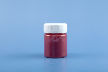 Red azo dye powder in plastic jar. Food additive E129. Allura Red AC is a popular dye used worldwide in food industry