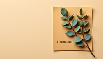 A flat lay on a beige surface with a cardboard congratulations sign, green artificial leaves, and a message indicating success or accomplishment.