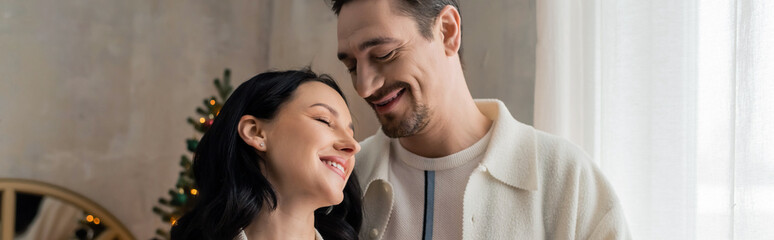 Naklejka premium Couple joyfully celebrating Christmas and New Year together at home