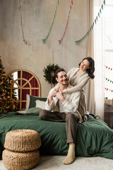 Obraz premium Happy couple joyfully celebrating Christmas and welcoming New Year at home