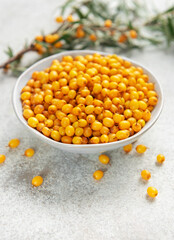Sea buckthorn berries in bowl with branches