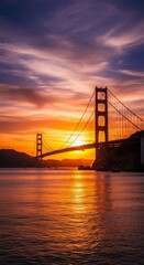Fototapeta premium Golden gate bridge at sunset with vibrant sky and ocean reflections