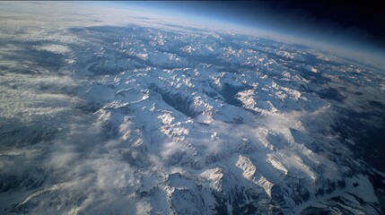 Aerial view of snow capped mountains against blue sky and wispy clouds