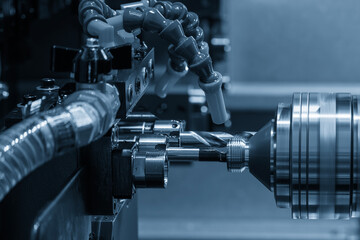 The multi tasking CNC lathe machine Swiss type bore cutting process the metal tube parts in the light blue scene.