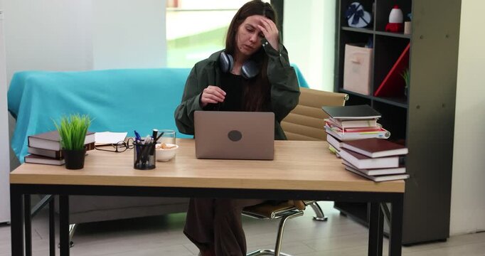 Woman accountant shows calculator and notepads stack on video call in office. Female manager explains level of work overloading at online meeting