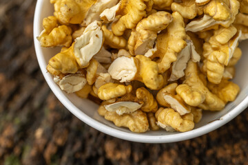 Walnut peeled kernels and whole walnuts on rustic wooden background. Healthy nuts food. Macro. Cracked shells