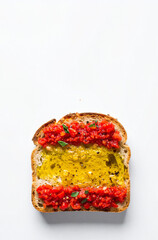 Pan con tomate natural y aceite de oliva virgen sobre fondo blanco, alimento de la gastronomía española y los colores de la bandera de España