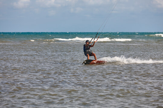 Mature man practicing kitesurfing. Aquatic sport. Athletic healthy senior