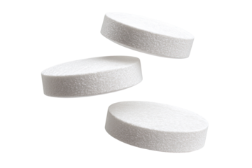 Three white pills in mid-air