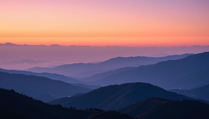 Obraz premium A panoramic view of a hilly landscape during either sunrise or sunset. The sky is rich with warm, vibrant colors that transition from orange near the horizon to cooler tones higher up in the sky