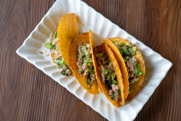 Close-up of Mexican-style tacos with ground tuna fish and vegetables