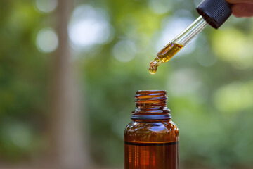 The brown glass bottle of essential oil is isolated with a dropper cap on a white background for health and pharmacy use