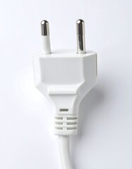 Close-up of a white electrical plug.  Two metal prongs extend from a white plastic casing.  A cord is visible