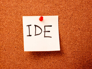 IDE handwritten note pinned on cork bulletin board