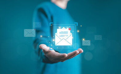 Businessman holding a glowing email icon with a message notification, representing digital communication, email marketing, online connection, and business correspondence technology. Email contact us