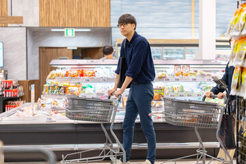 スーパーマーケットで買い物をする男性