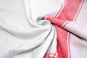 White cotton fabric with red checkered pattern folded on surface