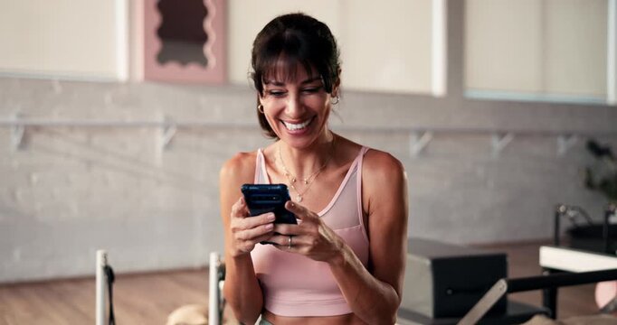 Texting, laugh or mature woman in gym with phone, funny message or training video on digital app. Happy, virtual or female person in club with tech, online tutorial or meme reaction on workout break.