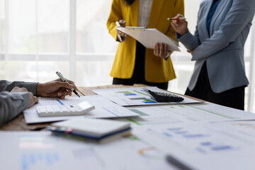 Business people team working with financial data analyzing charts and graphs using calculator and...