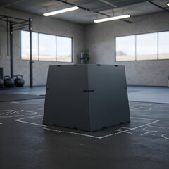Dark gray exercise box in a modern gym. ? Empty box sits on a matted floor with chalk markings in a spacious training facility.