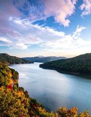 Serene autumnal vista of a winding lake nestled in a mountainous landscape