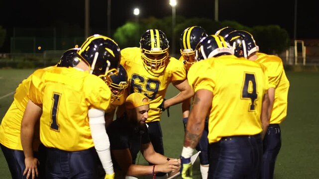 American football team coach discussing game strategy with players