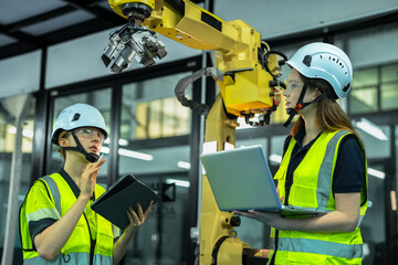 In an Industry 4.0 smart factory, an engineer uses a tablet to run an AI machine vision algorithm on a collaborative robot cobot, optimizing production via a real time digital twin.