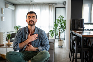Man practicing mindful breathing meditation for relaxation at home