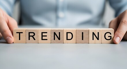 Hands holding wooden blocks spelling out the word trending