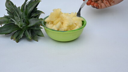 Pineapple or Ananas comosus slices on white background. It is a&nbsp;tropical plant&nbsp;with an edible fruit. It is plant in the family&nbsp;Bromeliaceae. Pineapple pieces in a bowl ready to eat.