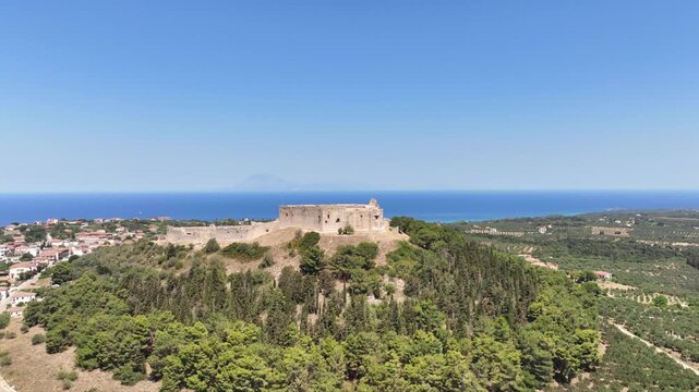 Aerial drone cinematic video of Frankish Castle of Chlemoutsi in area of Kylini overlooking small village of Kastro and deep blue sea, Peloponese, Ilia, Greece