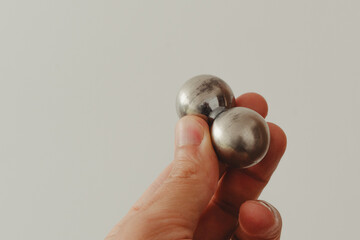 CNC spheres in a man's hand, daylight highlights their form. A symbol of two poles and the force that holds them. A vision of power, balance, and precision.