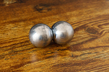 CNC spheres on a wooden desk in daylight. A symbol of polarity, brain hemispheres, control, geomagnetic shift, psychedelia, and climate change.