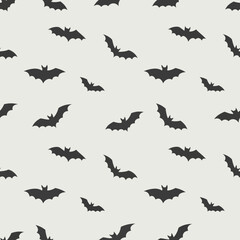 Dark silhouette bats scattered across a light background creating a spooky pattern.
