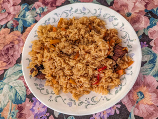 Uzbek Plov Rice Dish with Beef and Vegetables Served on a Floral Tablecloth