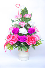 Beautiful bouquet of artificial roses in pink, purple, and white arranged in a ceramic vase with a heart-shaped card holder. Perfect for romantic, congratulations or home decoration.   