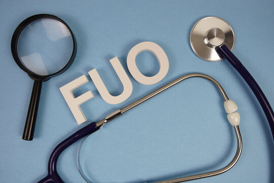 FUO Fever Of Unknown Origin text with Stethoscope and magnifying glass on blue background
