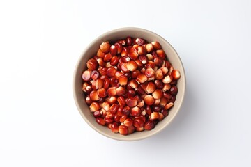Ripe red corn kernels in bowl on white table, top view