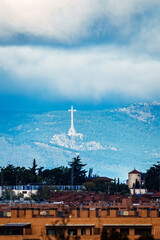 Huge cross towering over Valley of the Fallen, Madrid, under cloudy sky