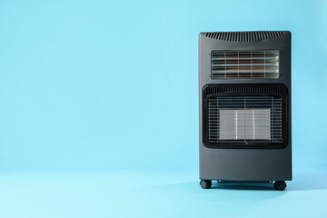 Obraz premium Electric heater on light blue background. Space for text