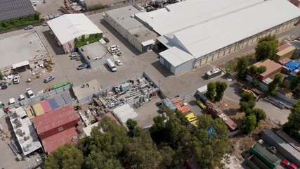 Miluot, Israel - 14 May 2025: Aerial view of the industrial zone, where warehouses and buildings stand in organized rows, bathed in the soft light of midday.