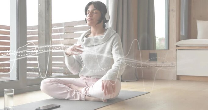 woman wearing headphones with audio guide placing hand on chest breathing waves guiding meditation